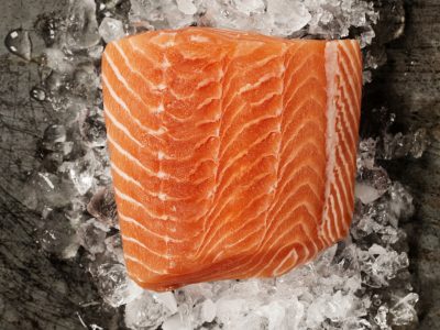 Raw salmon fillet and ingredients for cooking in a rustic style. Top view